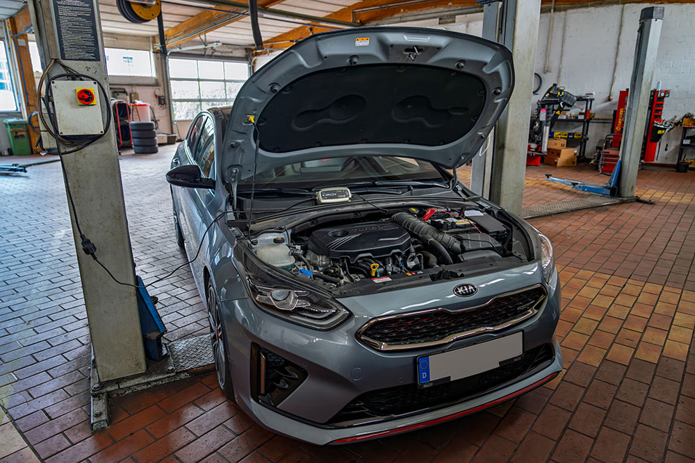 Vehicle with its bonnet open inside the Autohaus Bürkle workshop.