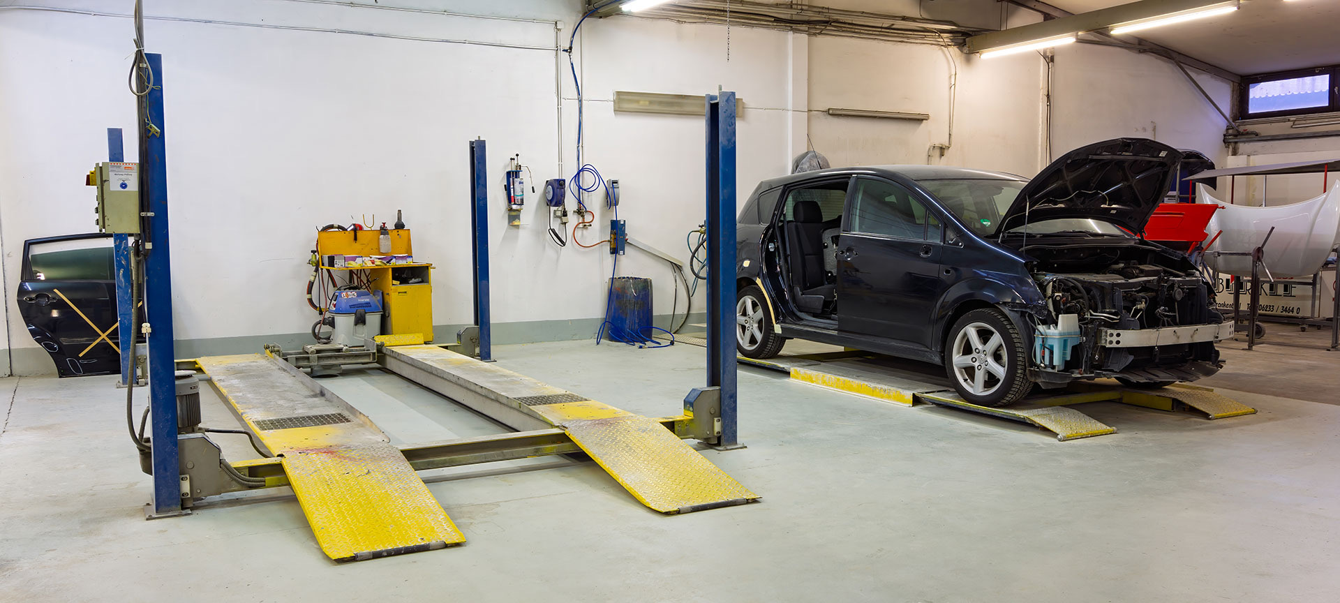 Beschädigtes Fahrzeug auf einer Hebebühne in der Werkstatt des Autohauses Bürkle.